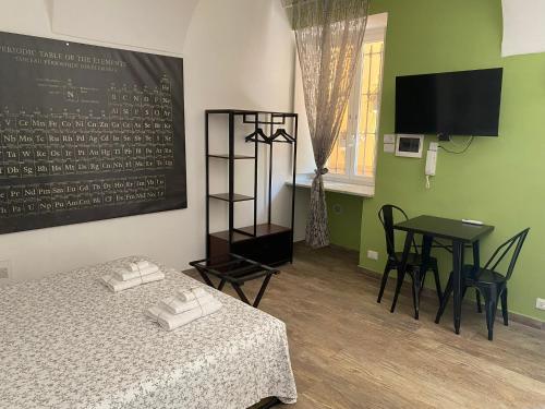 a room with a bed and a table and a television at Chagall Charme in Asti