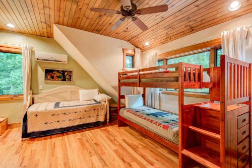 a bedroom with two bunk beds and a ceiling fan at The Guf in Sugar Grove
