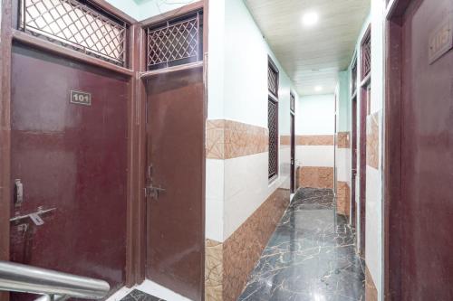 KaliānpurにあるSPOT ON New Shukla Hotelのバスルーム(茶色のドア、タイルフロア付)