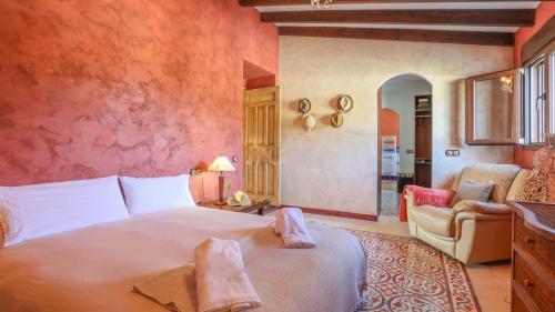 a bedroom with a large bed and a chair at La Sanadora, maravilla andaluza in Saucejo