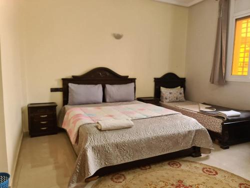 a bedroom with a large bed and a night stand at blue door imsouane in Imsouane