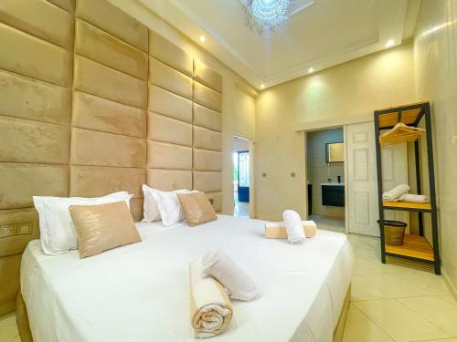 a bedroom with a large white bed with towels on it at Nassau FarmHouse in Mellah Bakka