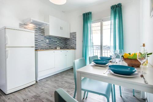 パシュマンにあるMama Rozaのキッチン(白い冷蔵庫、テーブル、椅子付)