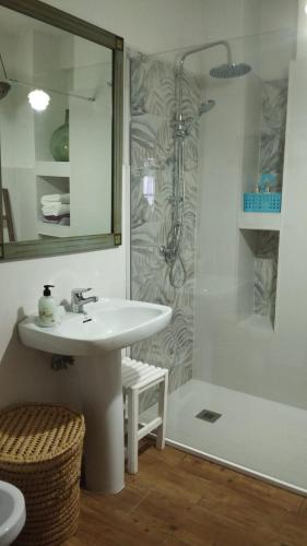 a white bathroom with a sink and a shower at El rinconcito in Fuenteheridos