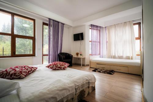 a bedroom with a bed with two pillows on it at Pensiunea Alexandra in Predeal