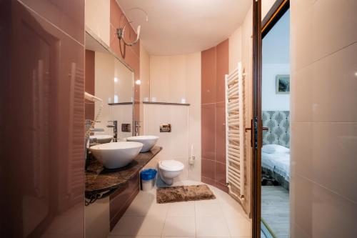 a bathroom with two toilets and a sink at Pensiunea Alexandra in Predeal