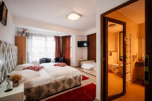 a hotel room with two beds and a mirror at Pensiunea Alexandra in Predeal