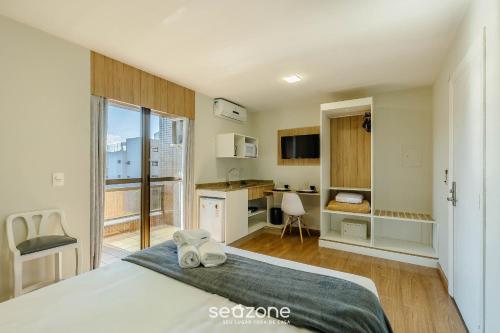 Un dormitorio con una cama y una cocina y un escritorio. en Estudios at Upper Residence - UPP, en Curitiba