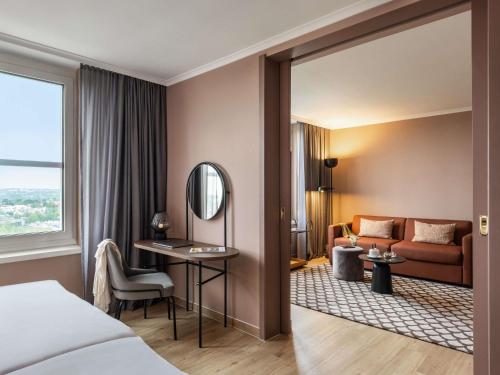a hotel room with a bed and a mirror at PULLMAN Stuttgart Fontana in Stuttgart