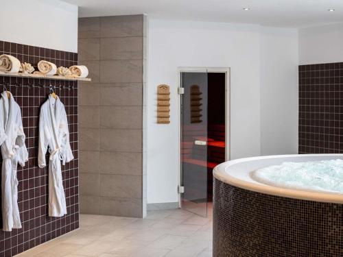 a bathroom with a tub and a shower at PULLMAN Stuttgart Fontana in Stuttgart