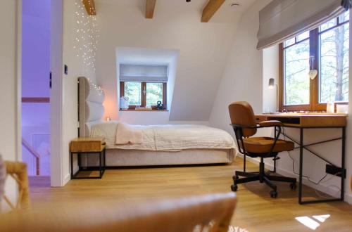 a bedroom with a bed and a desk in a room at Forest Home Dębowa 18 in Łuka