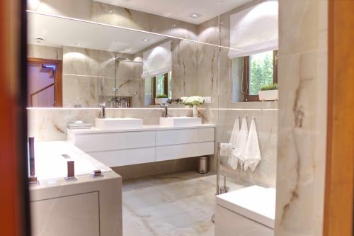 a bathroom with two sinks and a large mirror at Forest Home Dębowa 18 in Łuka