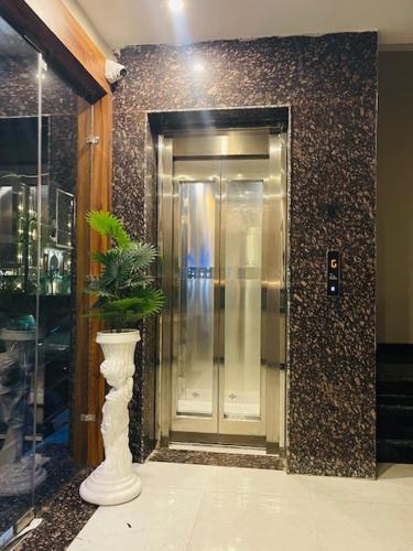 a elevator in a building with a plant in a vase at Hotel Lake Casa in Bathinda