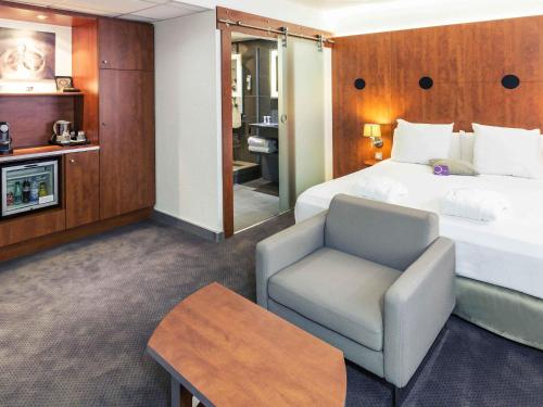 a hotel room with a bed and a chair at ibis Styles Béziers Centre in Béziers