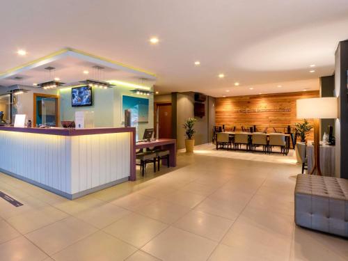 a lobby with a bar and a dining area at Mercure Florianópolis in Florianópolis