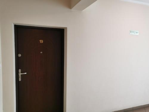 a brown door with a number on it in a room at Apartament Kamil in Poznań