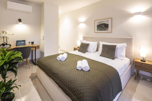 a bedroom with a bed with white shoes on it at Casa Milhafre Real in Benagil