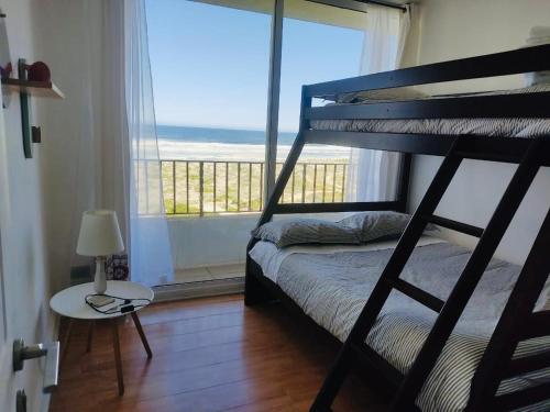 a bedroom with a bunk bed with a view of the ocean at Tramonto Sul Mare en Serena Golf in La Serena