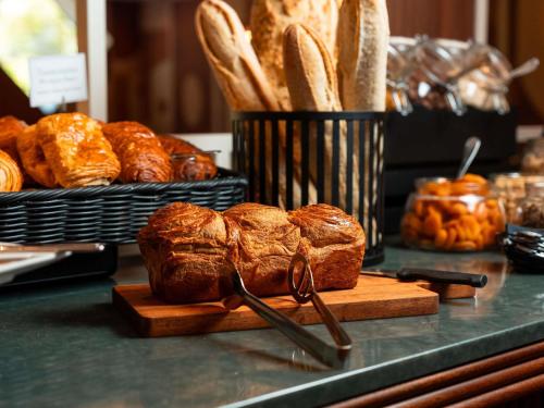 un tas de pain et de viennoiseries posés sur un comptoir dans l'établissement Mercure Caen Cote De Nacre, à Caen