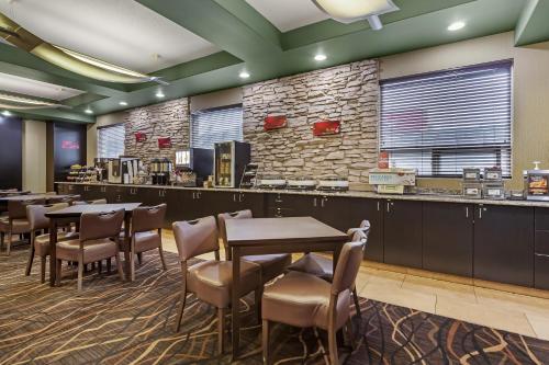 a restaurant with tables and chairs and a stone wall at Best Western Plus St Albert in St. Albert