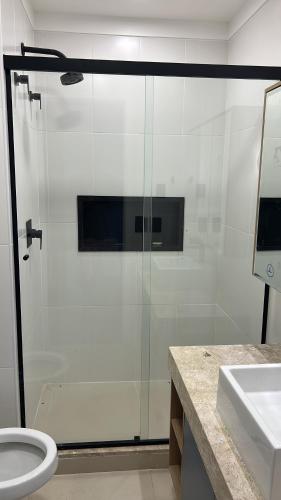 a bathroom with a shower with a toilet and a sink at Apto 2306 in Santos