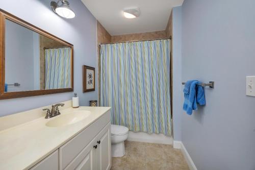 a bathroom with a sink and a toilet and a mirror at 10 Waterfront Drive, #312 in Saint Simon Mills