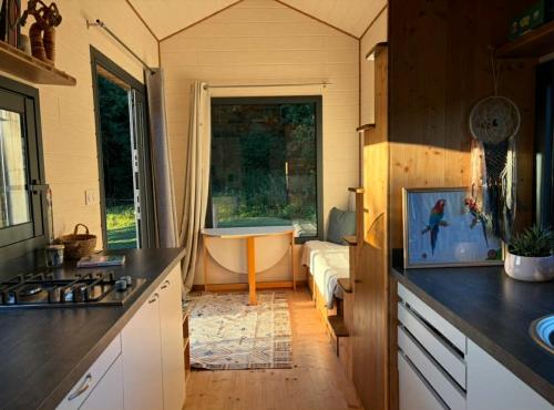 a kitchen with a tub and a sink and a bathroom at La Tiny de Mary in Gonneville-sur-Mer