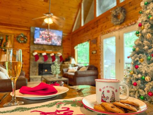a living room with a christmas tree and a table with a cup of coffee at Charming Cabin, Seasonal Decor & Pool, 3min to Pkwy, Grill, GameRoom, Wifi & Workstation, Sleeps 14 in Pigeon Forge