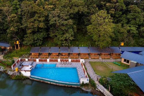 an aerial view of a house with a swimming pool in the water at Dandeli Tiger Cottages in Dandeli