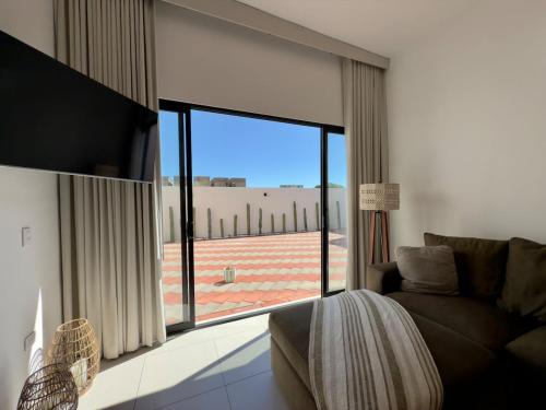 a living room with a couch and a large window at Modern beach house in San Carlos in San Carlos