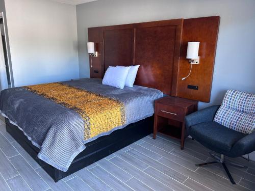 a hotel room with a bed and a chair at Airport Motor Inn in Jacksonville
