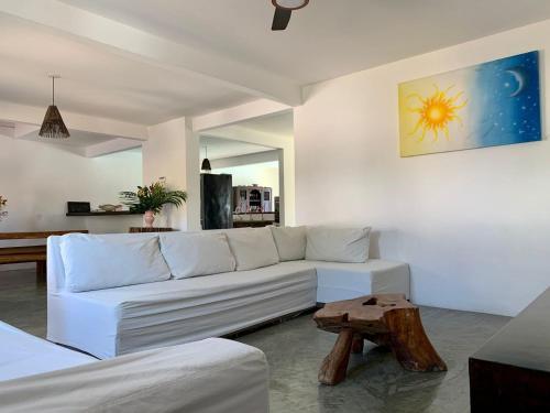 un soggiorno con un divano bianco e un tavolo di Casa c piscina em condominio na Praia do Espelho a Praia do Espelho