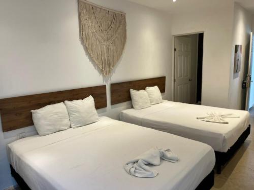 two beds in a hotel room with towels on them at Coco Live Suites in Playa del Carmen