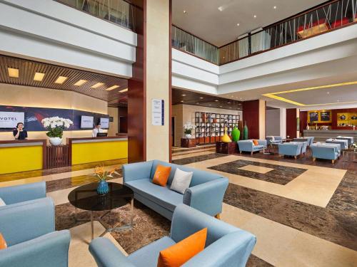 a lobby with blue couches and chairs and a library at Novotel Nha Trang in Nha Trang