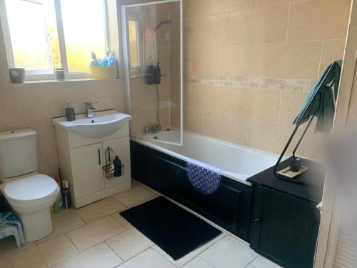 a bathroom with a tub and a sink and a toilet at cosy room by c in London