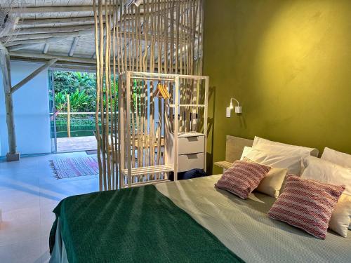 a bedroom with a bed with two pillows on it at suíte Saíra in Ubatuba