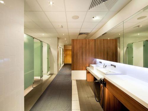 a bathroom with two sinks and a mirror at Novotel Cardiff Centre in Cardiff