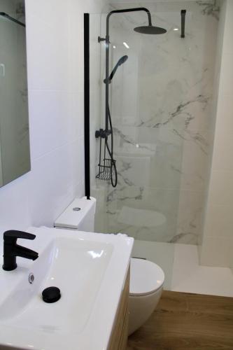 a white bathroom with a shower and a sink at Estudio Finca Mas el Bravo in Caudiel
