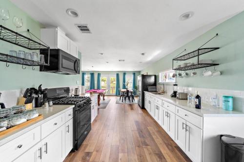 eine große Küche mit weißen Schränken und schwarzen Geräten in der Unterkunft Elevated Stay Near Pier, Beach Bbq Wifi Games in Galveston