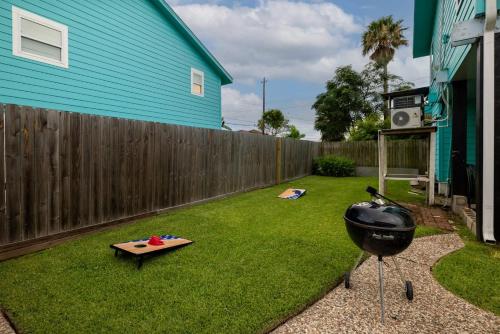 a backyard with a grill and a fence at Elevated Stay Near Pier, Beach BBQ WiFi Games in Galveston