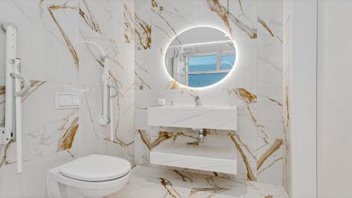 a bathroom with a white toilet and a mirror at Candlewood Suites Reykjavik by IHG in Reykjavík