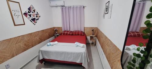 a small room with a bed and a mirror at Precioso Lar 2 in Gramame