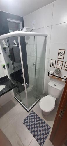 a bathroom with a glass shower and a toilet at Precioso Lar 2 in Gramame