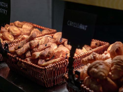 two baskets filled with different types of bread at Novotel Kuala Lumpur City Centre in Kuala Lumpur