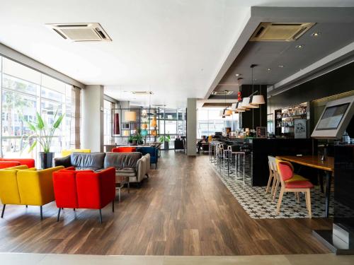 a restaurant with colorful chairs and a bar at Novotel Lima San Isidro in Lima