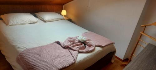 Una cama con un vestido con una flor. en Holiday Home Dragonfly, en Quartino