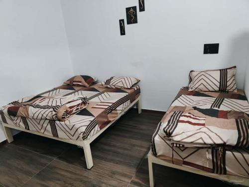 two beds sitting in a room with at SHIV SHAKTi HOMESTAY in Kevadia