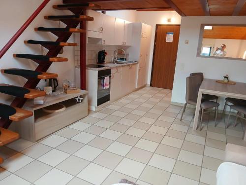a kitchen with a spiral staircase and a dining room at Holiday Home Dragonfly in Quartino
