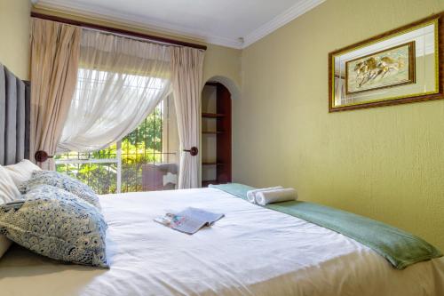 a bedroom with a large white bed with a window at Spacious and homely 4-bed home in Honey Hills in Roodepoort