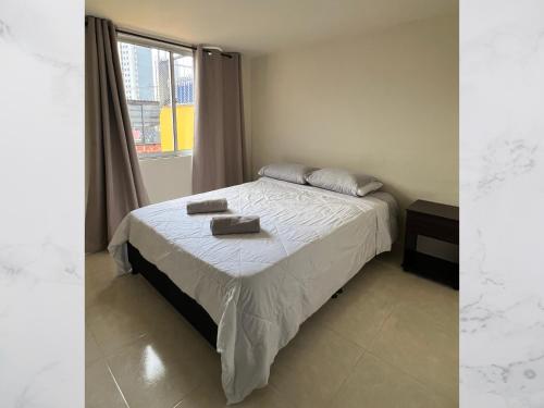 a bedroom with a bed with two towels on it at Casa amoblada 15 personas 6 habitaciones 4 baños - Frente al terminal y cable aereo, Cerca de Expoferias, Bosque Popular y Termales del Otoño in Manizales
